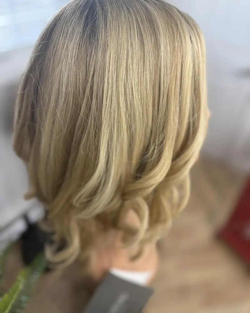 Blonde wig on a stand, back view